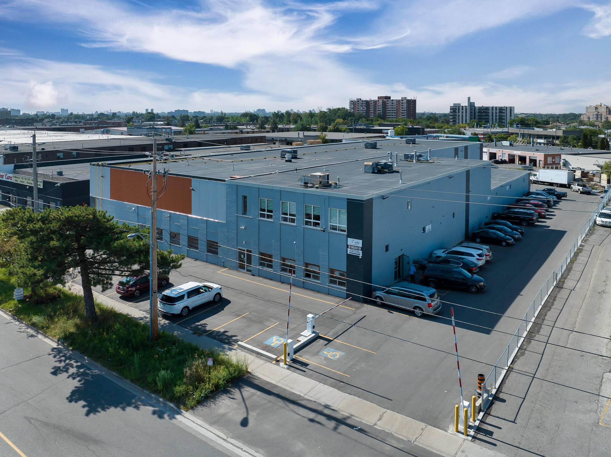 "Exterior view of ATH building with a parking lot and urban landscape in the background"