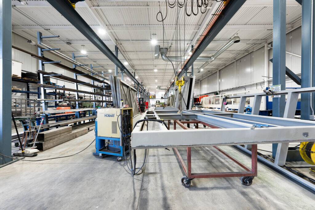 "Interior view of ATH Custom Metal Fabrication workshop showing various metalworking equipment and materials."