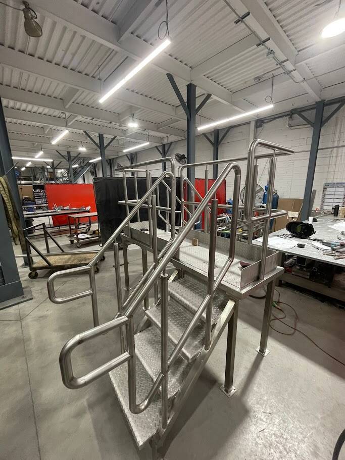 "Newly constructed custom metal staircase by ATH in an industrial workshop"